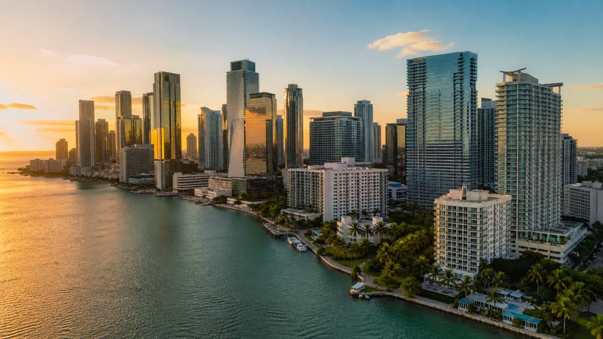 Aerial view of Miami Brickell skyline at golden hour with Biscayne Bay reflecting modern luxury skyscrapers